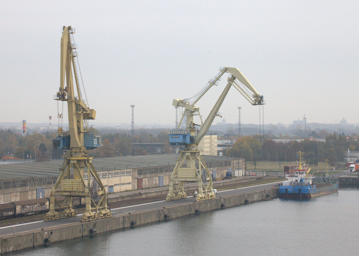 Blick vom Deck der Peter Pan auf 2 typische TAKRAF Hafenkräne in Rostock-Warnemünde.
Im Hintergrund das Küstenmotorschiff Zingst. 01.11.2018  13:58 Uhr.