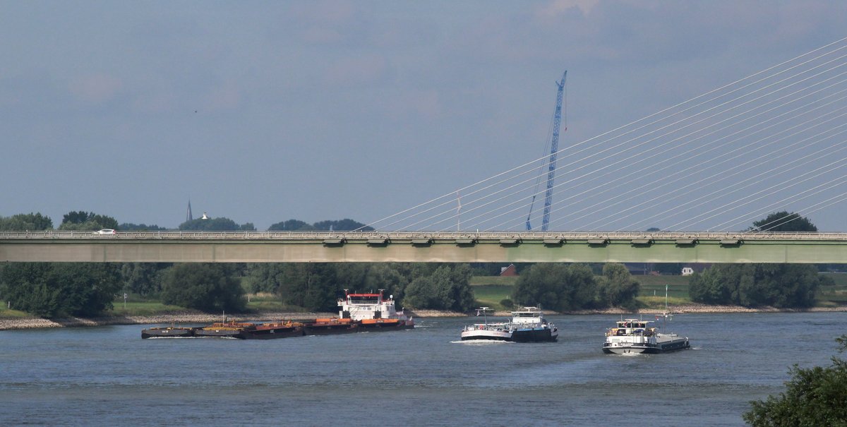 Blick von Rees auf den Rhein und die Brücke der B67 am 09.07.2017. Ein Schubverband mit 6 beladenen Leichtern und einem Veerhaven-SB kommt vo Rotterdam zu Berg und wird von einem TMS überholt. Ein GMS fährt zu Tal Richtung Niederlande. 