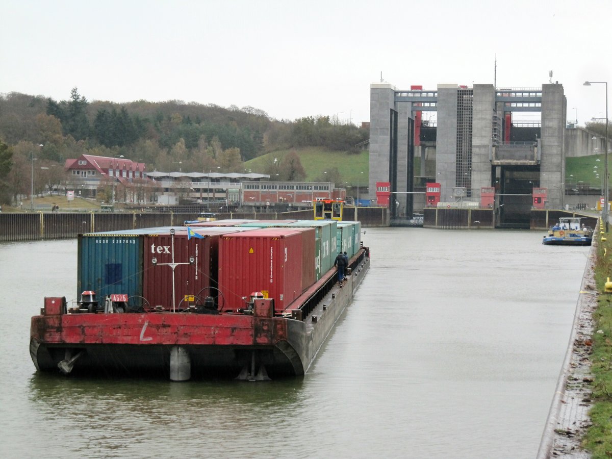 Blick vom unteren Vorhafen auf das Schiffshebewerk Lüneburg-Scharnebeck am 20.11.2016 bei miserablem Wetter. Der Container-Schubverband mit SB Schubexpress 10 (05602700) hatte gekoppelt und fuhr dann im Elbe-Seitenkanal zu Tal Richtung HH. Vorne rechts liegt das TMS Paul Burmester (04800220) und wartet auf die Fahrstuhlfahrt.