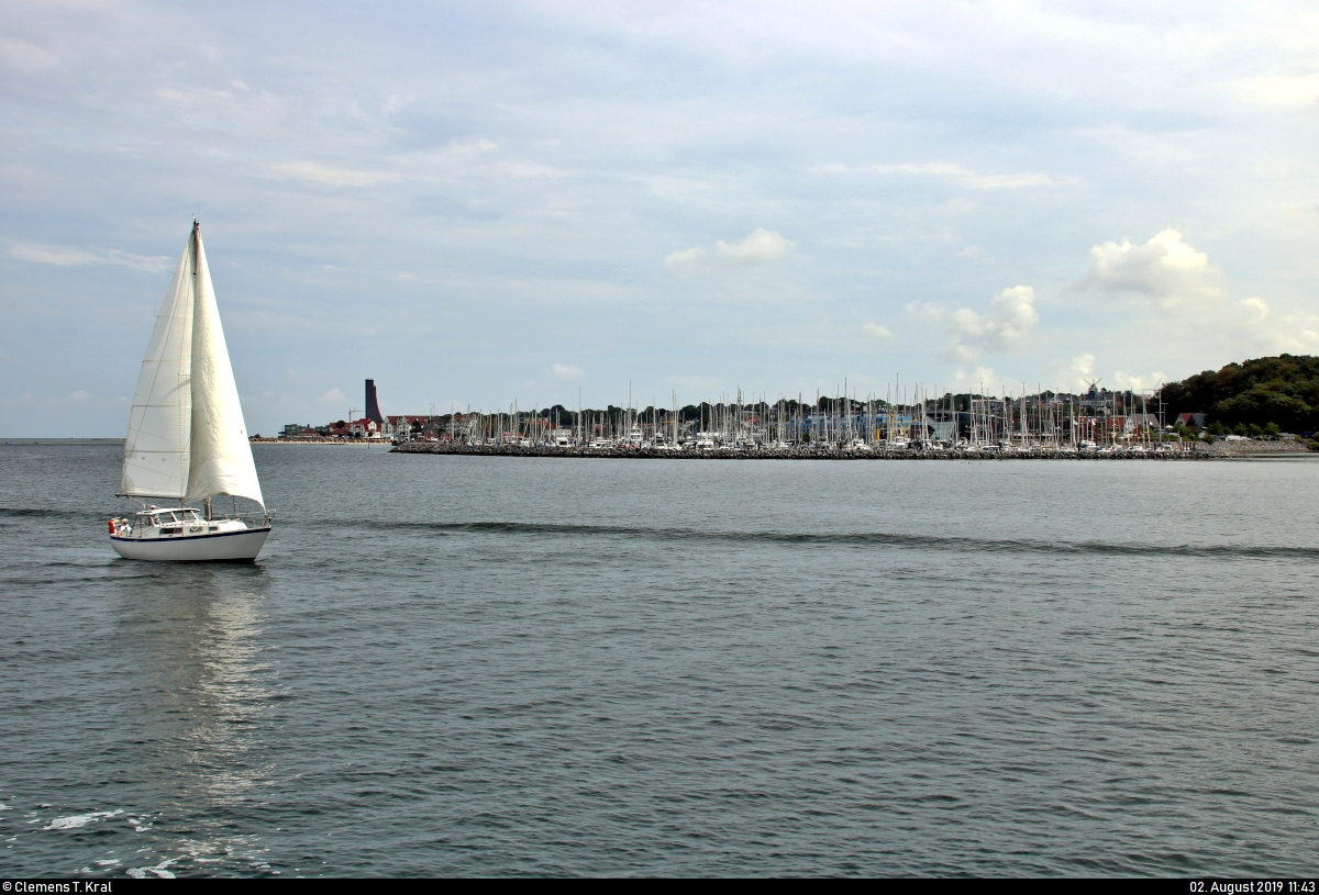 Blick während einer Hafenrundfahrt auf den Yacht- und Gewerbehafen des Ostseebads Laboe mit Segelboot im Vorder- und Marine-Ehrenmal im Hintergrund.
[2.8.2019 | 11:43 Uhr]