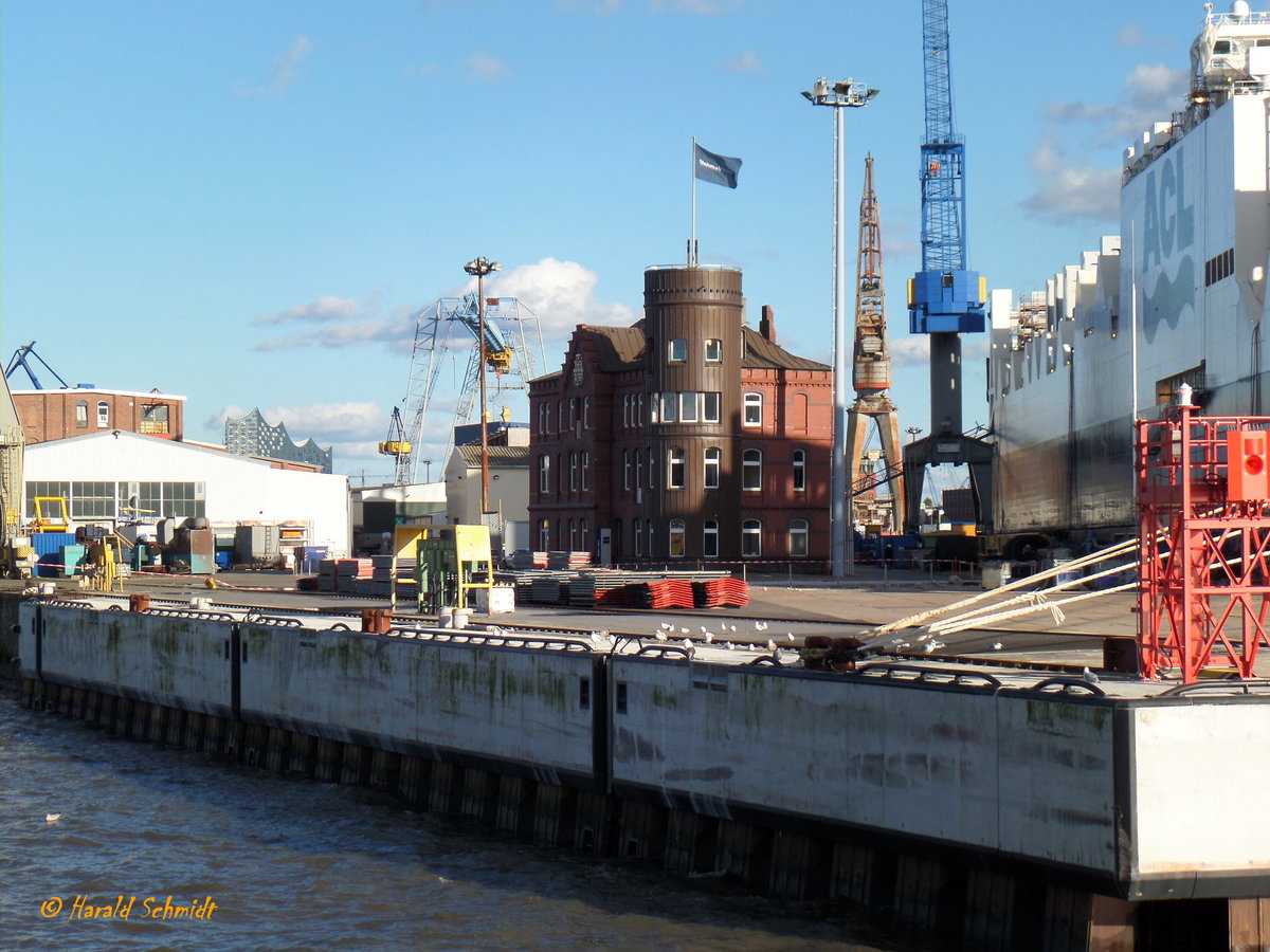 Blohm & Voss - Werft, altes Lotsenhaus, Hamburg-Steinwerder am 8.10.2017 /

Lotsenhöft
Das 1902 für die Hamburger Hafenlotsen erbaute Gebäude mit seinem runden Turm bildet die prägnante Westspitze des Werftgeländes. Im Jahr 1925 sind die Hamburger Hafenlotsen an ihren jetzigen Standort am Seemannshöft umgezogen. Seitdem wird das Gebäude von Blohm+Voss für Büros und Repräsentationszwecke genutzt. 2005 ist das denkmalgeschützte Gebäude aufwändig restauriert und instandgesetzt worden
