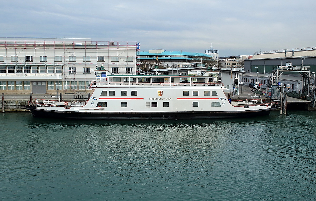 Bodenseeschifffahrt 3: Am 16.03.2018 liegt die Autofähre FRIEDRICHSHAFEN (55,50x12,20 m, 1.196 PS/880 kW, 12,4 kn) in Friedrichshafen, rechts daneben der Fähranleger. In dieser Form ist die ehemalige ROHRSCHACH seit dem Umbau 2000/2001 im Einsatz. Hinter dem ehemaligen Zollgebäude ist der erhalten gebliebene Aufbau der SCHUSSEN erkennbar.