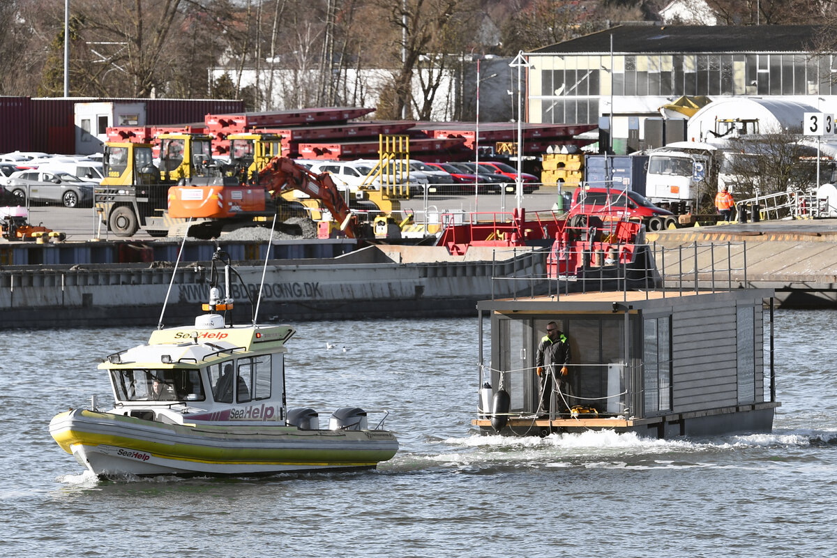 Boot von SEAHELP am 28.02.2023 im Hafen von Lübeck-Travemünde. Es schleppt ein Hausboot in Richtung Lübeck