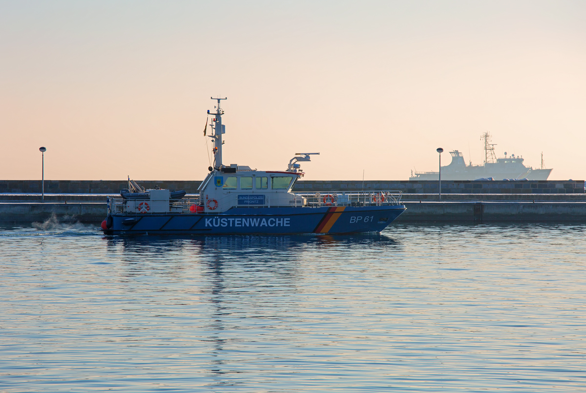 BP 61 „Prignitz“  der BP im Hafen von Sassnitz und hinter der Mole kreuzt die „Seeadler  (DBFC) des Fischereischutzes bei unsichtigem Wetter im Gegenlicht. - 23.01.2016