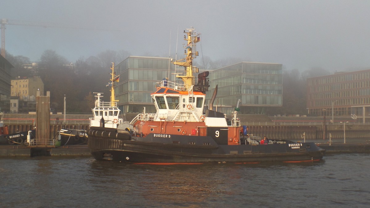 BUGSIER 9 (IMO 9429558) am 25.11.2014, Hamburg, Elbe, Schlepperstation Neumühlen / Wir hatten an diesem Tag in Hamburg stellenweise dichten Nebel. Wenn die Sonne durchkam, ergaben sich stimmungsvolle Fotos /

ASD-Schlepper / BRZ 485 / Lüa 33,1 m, B 12,6 m, Tg 6,1 m / 2 Wärtsilä-Diesel, ges. 4800 kW, 6528 PS, 2 Rolls-Royce Ruder-Propeller in Kortdüse, 14 kn, Pfahlzug 84 t / 2009 bei Gemsan Shipbuilding Industry, Istanbul, Türkei /
