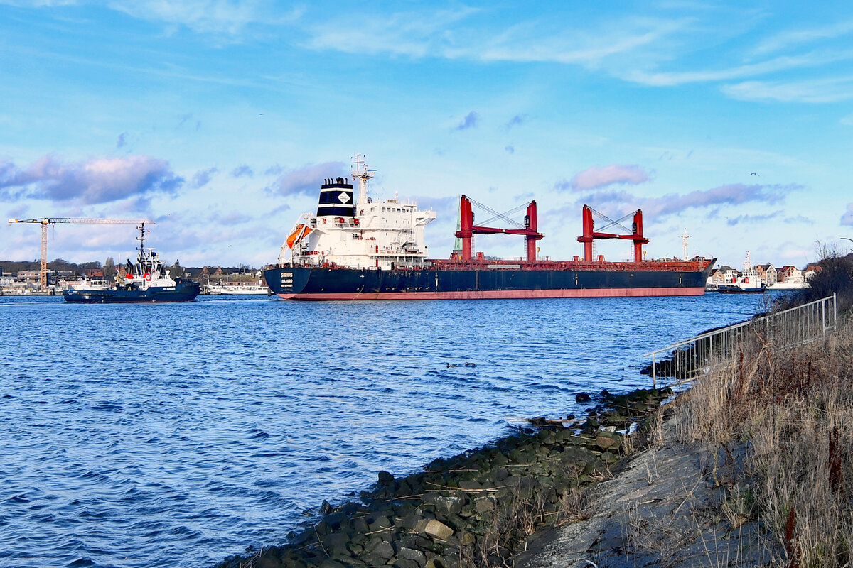 Bulk Carrier SIRIUS (IMO 9541887) mit Schlepper VB RÖNNEBECK und VB ARGUS am 01.01.2023 in Lübeck-Travemünde