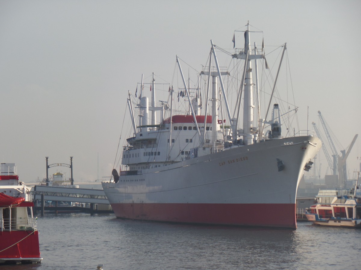 CAP SAN DIEGEO (IMO 5060794) bei aufbrechendem Nebel am 14.1.2014, am Dauerliegeplatz an der Überseebrücke, Hamburg / 
ex Sangria (1986), San Diego (1982), Cap San Diego (1962) / Stiftung Hamburger Admiralität, Hamburg / 
Stückgutfrachter /  bei Deutsche Werft Hamburg, 1962,  Nr. 785 / BRZ 9998 / Lüa. 159,4m, B 21,4m, Tg. 8,4m / 1 MAN 9-Zyl. 2-Takt Diesel, 8569 kW, 11643 PS, 19 kn /  12 Pass. /
