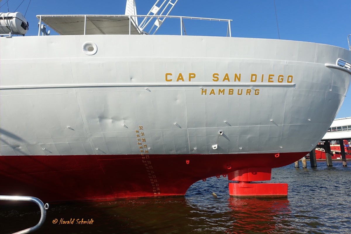 CAP SAN DIEGO am 3.9.2021, Hamburg, Elbe, am Dauerliegeplatz an der Innenkante Überseebrücke, Ausschnitt Heckpartie mit Namen, Heimathafen, Ruderkoker/Ruderhals und Tiefgangsmarke /

Ex-Namen: Sangria (1986), San Diego (1982), Cap San Diego (1962) / Stiftung Hamburger Admiralität, Hamburg / 

Stückgutfrachter (Museumsschiff)  /  gebaut 1962 bei Deutsche Werft Hamburg,  Nr. 785 / BRZ 9.998 / Lüa. 159,4m, B 21,4m, Tg. 8,4m / 1 MAN 9-Zyl. 2-Takt Diesel, 8.569 kW (11.643 PS), 19 kn /  12 Pass. /
