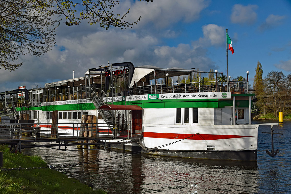 Das Betonschiff RIVERBOAT befindet sich seit den 1950er-Jahren in der Hansestadt Lübeck.Es ist 55 Meter lang und 7,5 Meter breit. Es wurde 1942 von DYWIDAG (Dyckerhoff & Widmann) in Holland gebaut. Dieses Schiff bzw. dieser  Schwimmkörper , wie es korrekt heißen muss, denn es verfügte nie über einen eigenen Antrieb, wurde ausschließlich geschleppt und sollte schweres Kriegsgerät über den Kanal bringen.
Nach Ende des Zweiten Weltkriegs diente es als Auffangstation für Flüchtlinge. 1956 wurde es unter der Lübecker Puppenbrücke vertäut und als Musikschiff (vor allem Jazz) eröffnet. 1978 wurde das Schiff auf die andere Seite des Holstentores, in den Holstenhafen, verbracht und als Diskothek wiedereröffnet. Als nach mehreren Anläufen auch hier der Erfolg langsam ausblieb, wurde das RIVERBOAT ein weiteres Mal verlegt;in den Klughafen (1994). Nach großen Umbau- und Sanierungsmaßnahmen öffnete im April 2007 das  neue  RIVERBOAT, jedoch nicht mehr als Diskothek, sondern als Veranstaltungszentrum. Das Restaurant  Seaside  bietet hier nunmehr  italienische Küche . Aufnahme vom 22.04.2017