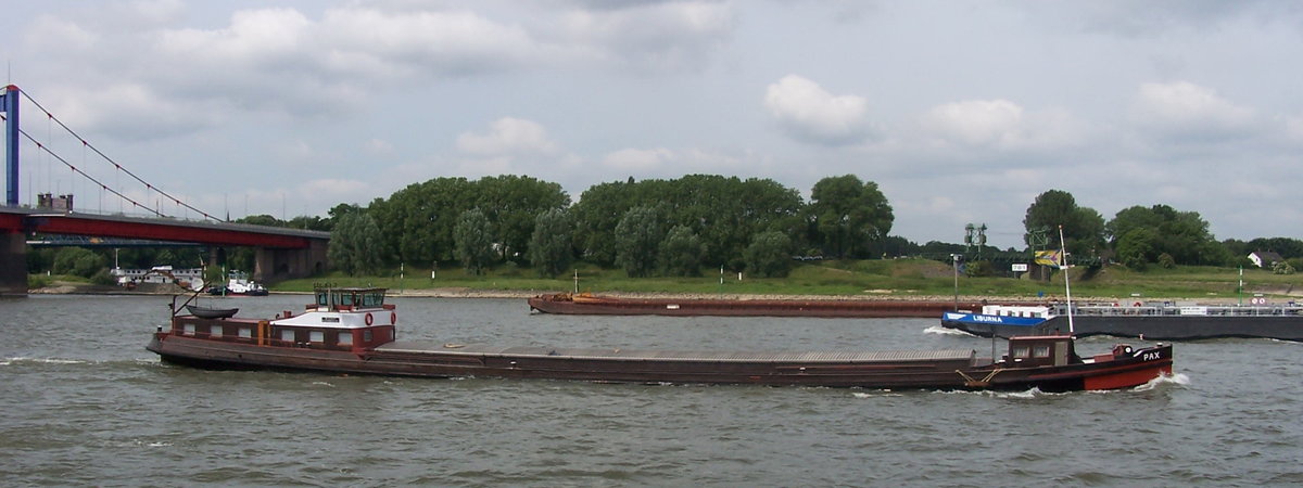 Das Binnen Frachtschiff PAX, Baujahr 1909 kann 500T Frachtgut befördern. Es hatte im
Laufe seines langen Daseins mehrere Namen, wie z.B. Donau oder Sophia. Das Bild ist aus 2005 und wurde kurz hinter der Friedrich - Ebert - Brücke in Duisburg aufgenommen.