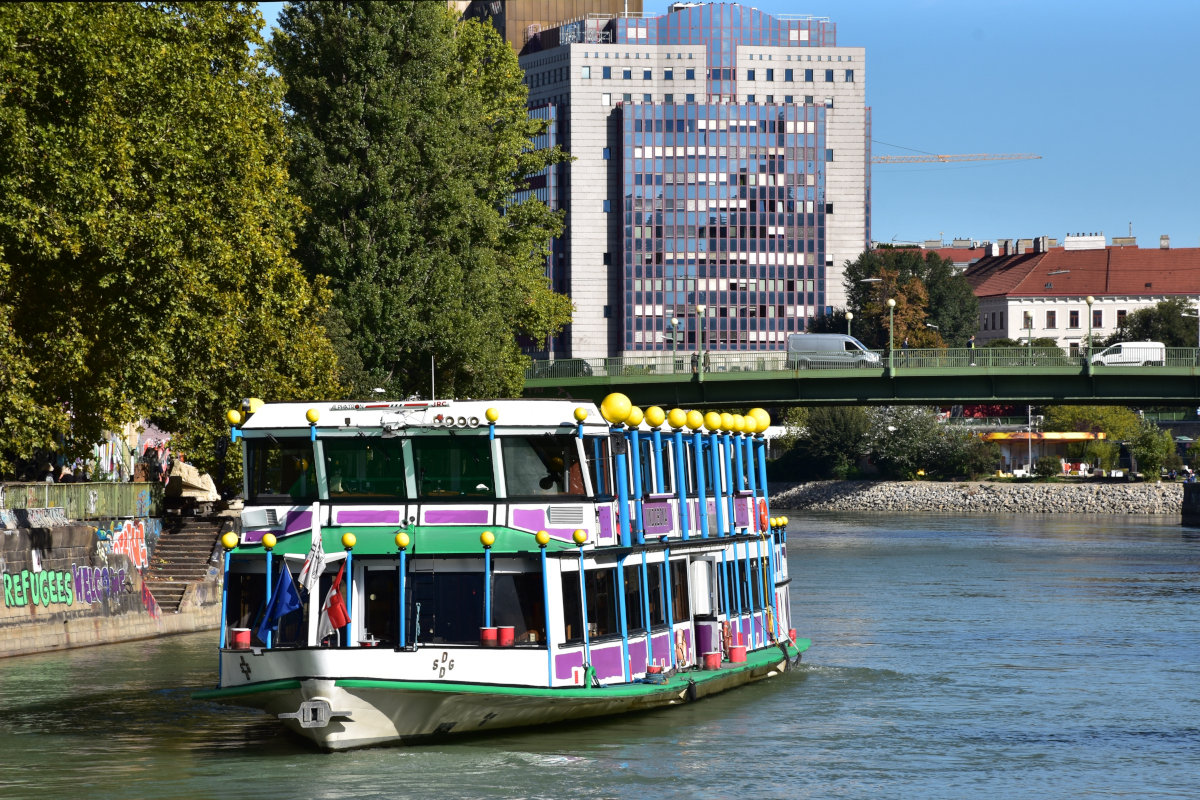 Das DDSG-Rundfahrtschiff VINDOBONA im Hundertwasser-Look auf dem Donaukanal in Wien nahe dem Schwedenplatz vor der Aspernbrücke, 2018-09-26