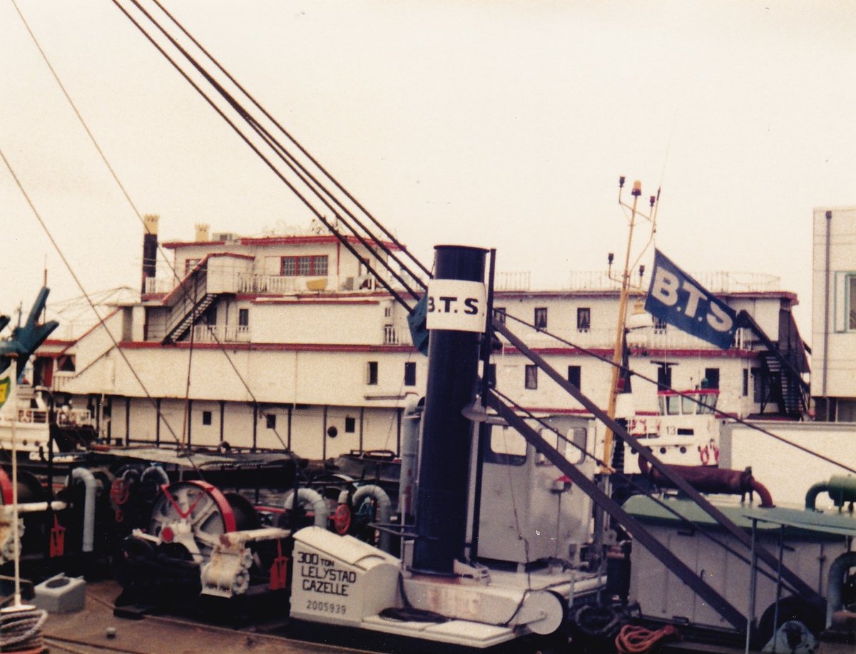 Das Foto zeigt einen Schaufelraddampfer, aufgenommen im Sommer 1987 in Rotterdam. Das Schiff lag an einer frei zugänglichen Stelle und wir haben es im Vorbeifahren durch Zufall gesehen. Das Schiff war beeindruckend groß, aber sehr heruntergekommen. Ein Schiffsname war nicht erkennbar. Durch die kleinen Fenster sieht er nicht wie ein Ausflugsdampfer aus. Da vorne 2 Schornsteine zu sehen sind, gehe ich von einem Dampfer aus. 
Davor liegt noch ein Schiff namens Gazelle oder Cazelle. Wer kann mir nähere Angaben zu dem Raddampfer im Hintergrund machen?