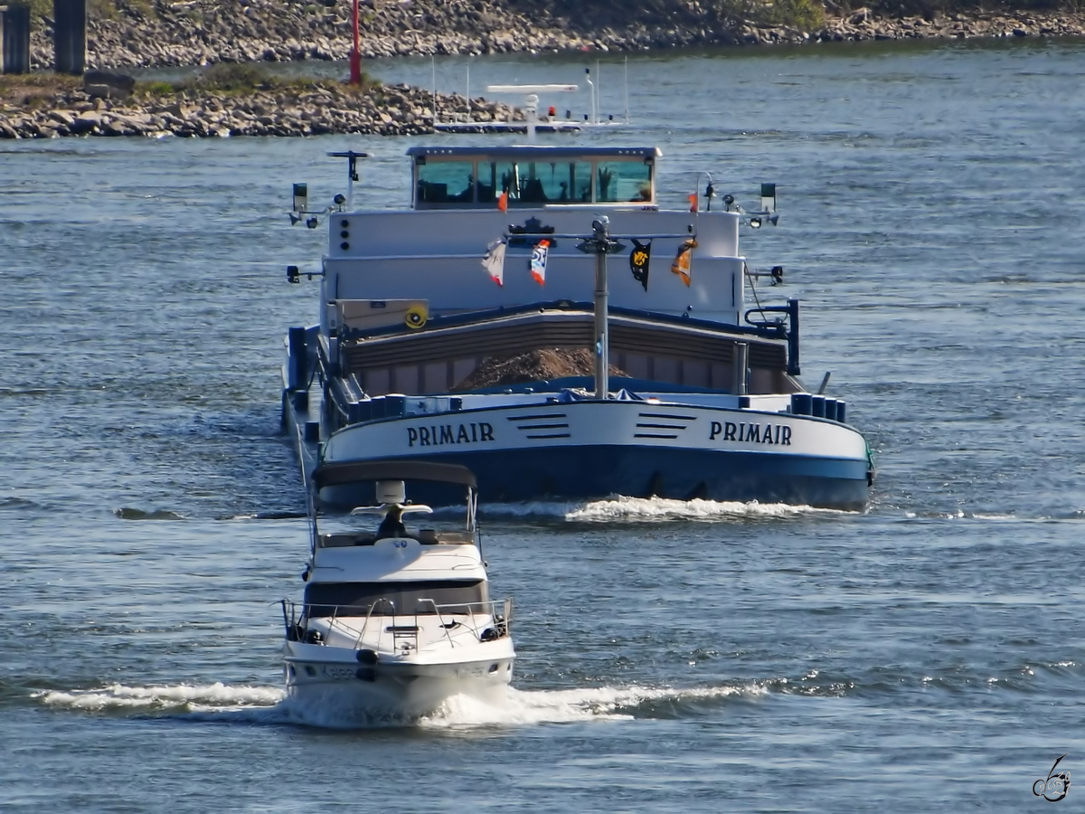 Das Gütermotorschiffe PRIMAIR (ENI: 02205685)  verfolgt  die Motorjacht KALEA auf dem Rhein bei Duisburg. (April 2021)