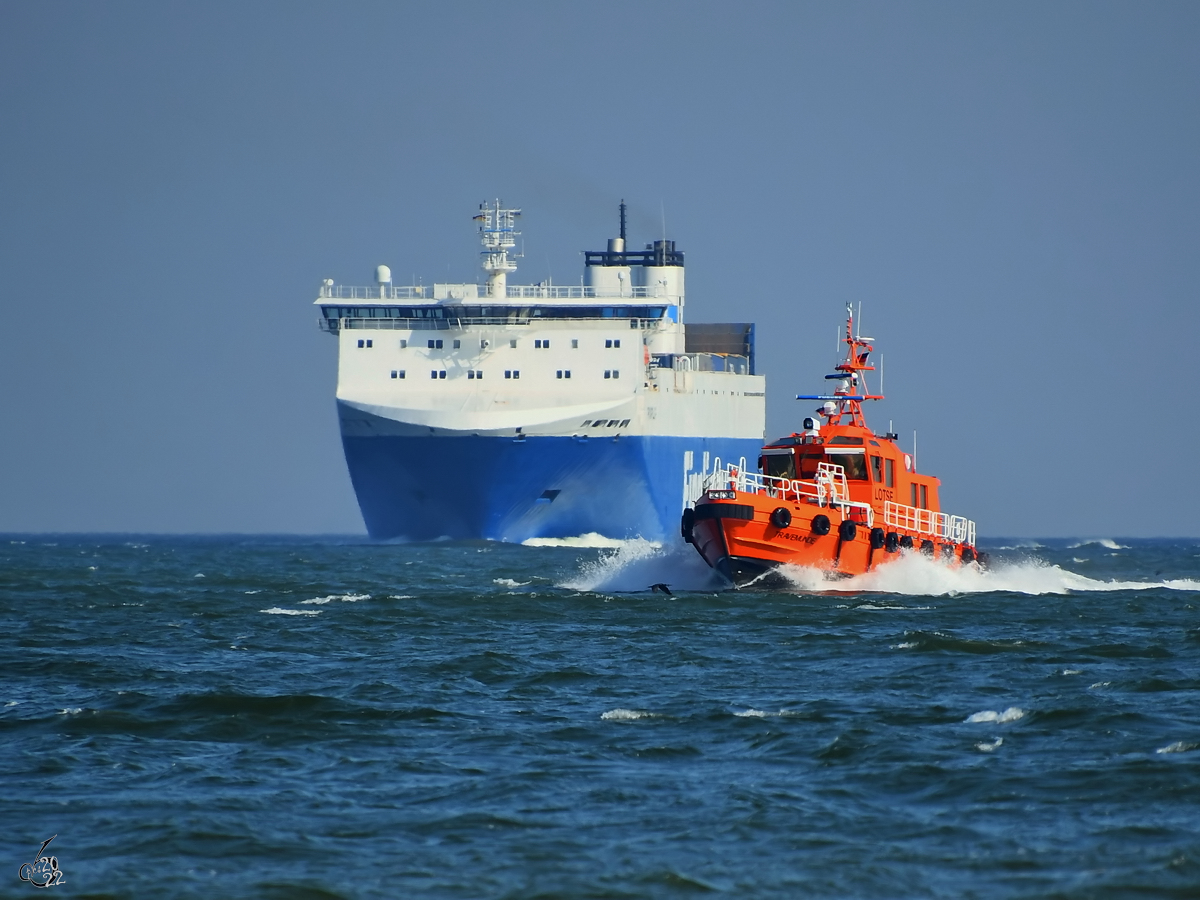 Das Lotsenboot TRAVEMÜNDE zieht am Fährschiff FINNPULP (IMO: 9212644) vorbei. (Priwall, März 2022)