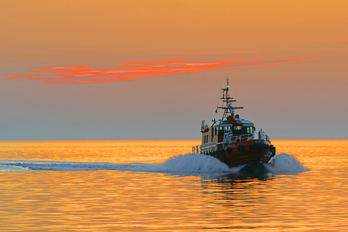 Das Lotsenversetzboot HOLTENAU kurz vor Sonnenaufgang des 4.8.2022 in der Ostsee vor Lübeck-Travemünde