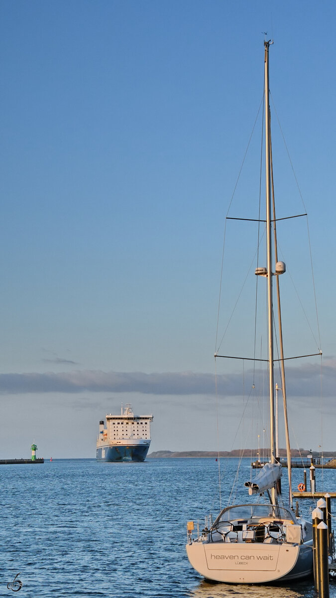 Das Segelboot HEAVEN CAN WAIT liegt im Passathafen von Priwall, im Hintergrund ist die Ankunft des Fährschiffes FINNLADY (IMO: 9336268) zu sehen. (Mai 2023)