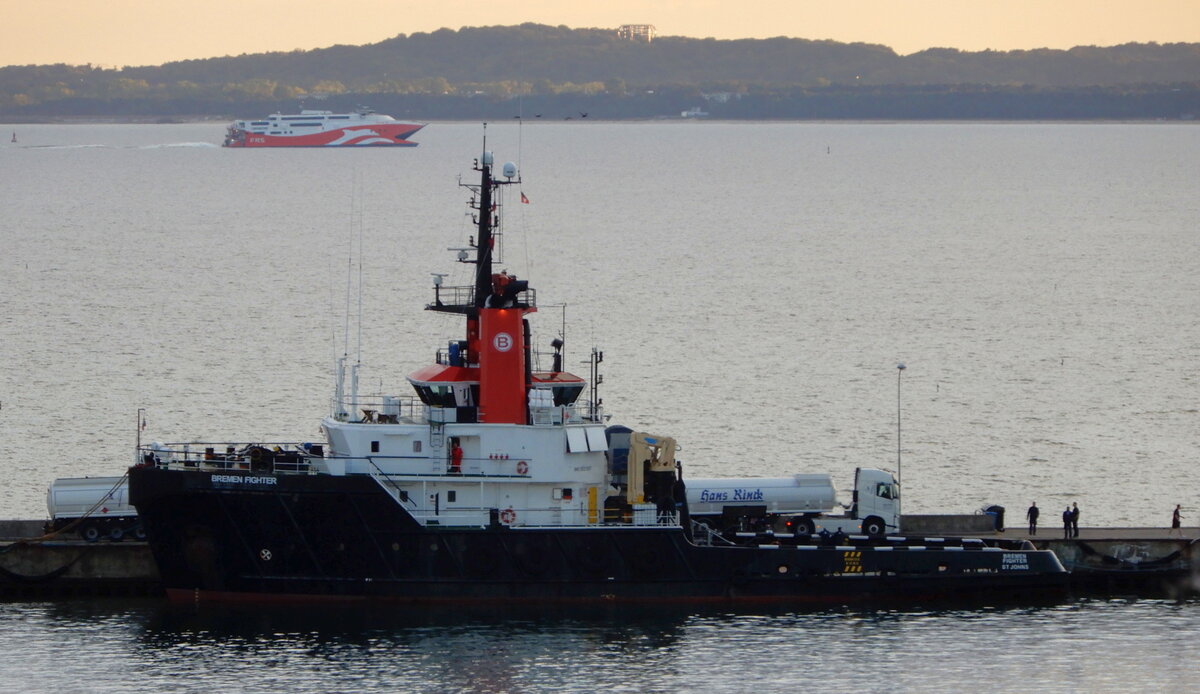 Der 48m lange Schlepper BREMEN Fighter am Abend des 06.10.21 in Sassnitz. Im Hintergrund ist die Fähre SKANE JET vor Mukran zu sehen.