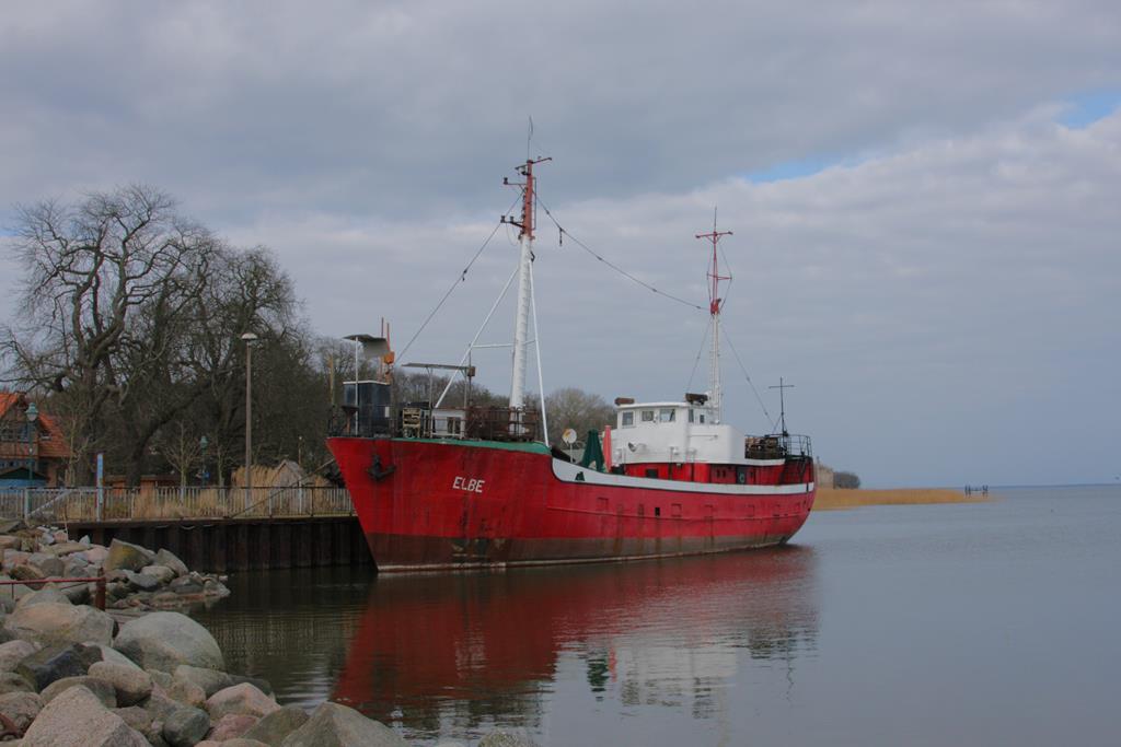 Der ehemalige Fischkutter ELBE liegt hier, heute als  Räucherschiff  genutzt, gut vertäut nahe der Festspielbühne in Ralswiek am Kai.