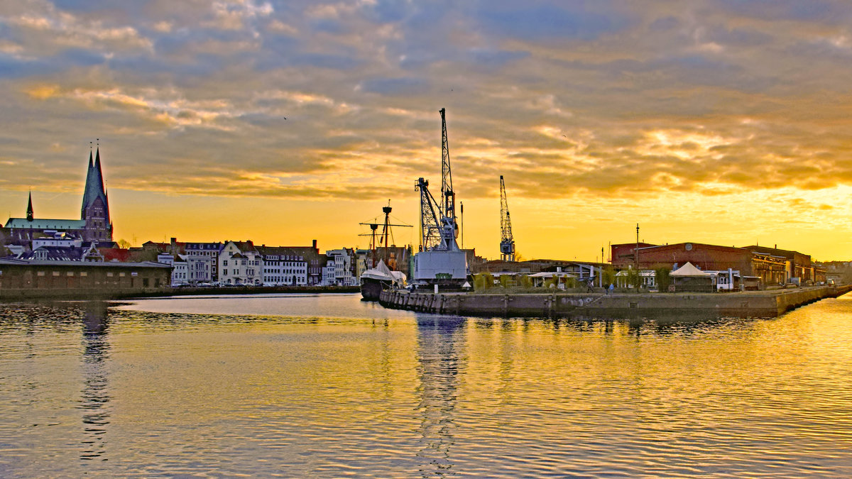 Der Hansahafen Lübeck und die nördliche Wallhalbinsel im Licht der untergehenden Sonne. Aufnahme vom 24.02.2021. Links der Bildmitte liegt die Kraweel LISA VON LÜBECK.