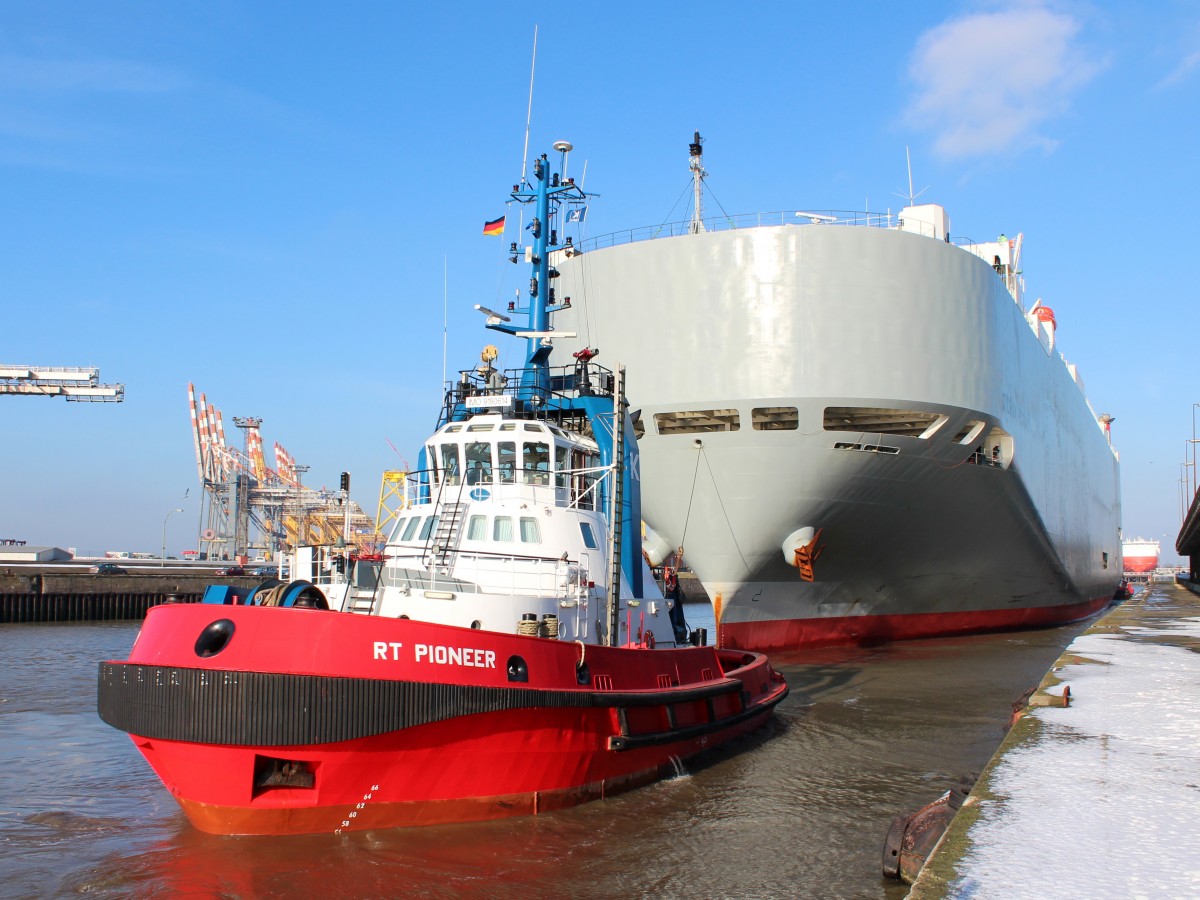 Der Schlepper RT Pioneer mit dem Autotransporter Georgia Highway am 28.01.2014 bei der Einfahrt in die Nordschleuse von Bremerhaven.