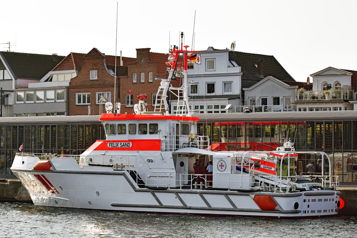 Der Seenotrettungskreuzer FELIX SAND am 4.9.2021 im Hafen von Lübeck-Travemünde. FELIX SAND ist erst vor wenigen Tagen, am 28.8.2021, getauft worden. FELIX SAND und Tochterboot SAPHIR entstanden auf der Werft Fr. Fassmer in Berne/Unterweser. Nach rund anderthalbjähriger Bauzeit wurden die Fahrzeuge Ende Januar 2021 unter den internen Bezeichnungen SK 41 und TB 45 abgeliefert. Seither hat der Neubau (Station Grömitz) bereits zahlreiche Einsätze gefahren. Erst vor knapp zwei Wochen retteten die Seenotretter mit SK 41 eine sechsköpfige Familie, darunter zwei kleine Kinder, aus akuter Seenot. 