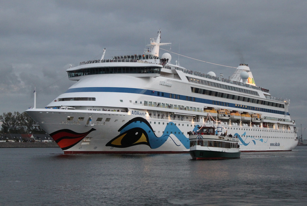 Die Aidaaura auf ihrem Seeweg von Warnemünde nach Hamburg am Abend des 17.10.2019 in Warnemünde neben an fuhr Das Fahrgastschiff Käpp´n Brass mit