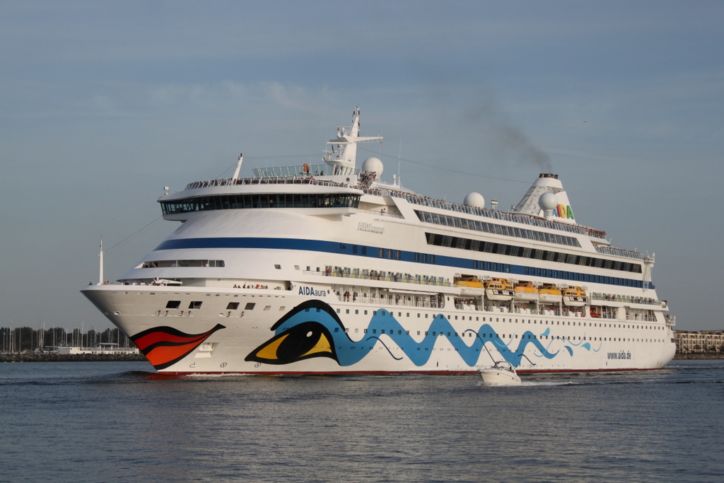 Die Aidaaura der Rostocker Reederei Aida Cruises auf ihrem Seeweg von Rönne nach Visby beim Auslaufen am Abend des 22.08.2019 in Warnemünde. 