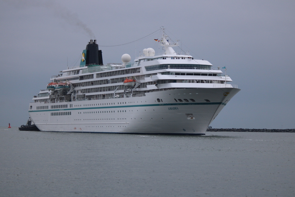 Die Amadea der Reederei Phoenix Reisen auf ihrem Seeweg von Hamburg nach Kopenhagen beim Einlaufen am 05.12.2021 mit Schlepper in Warnemünde 