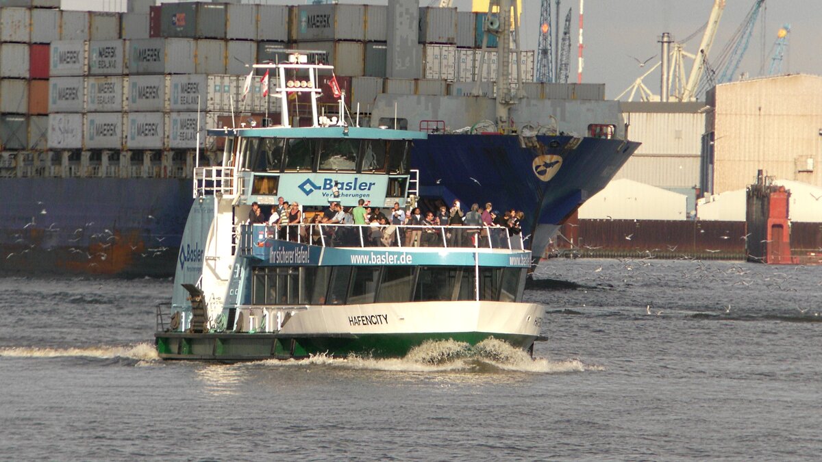 Die HADAG-Hafenfähre Hafencity fährt auf der Linie 62 nach Finkenwerder und erreicht in Kürze den Anleger Dockland (Fischereihafen). Im Hintergrund ist die Maersk Niamey zu sehen. (29.07.2017)