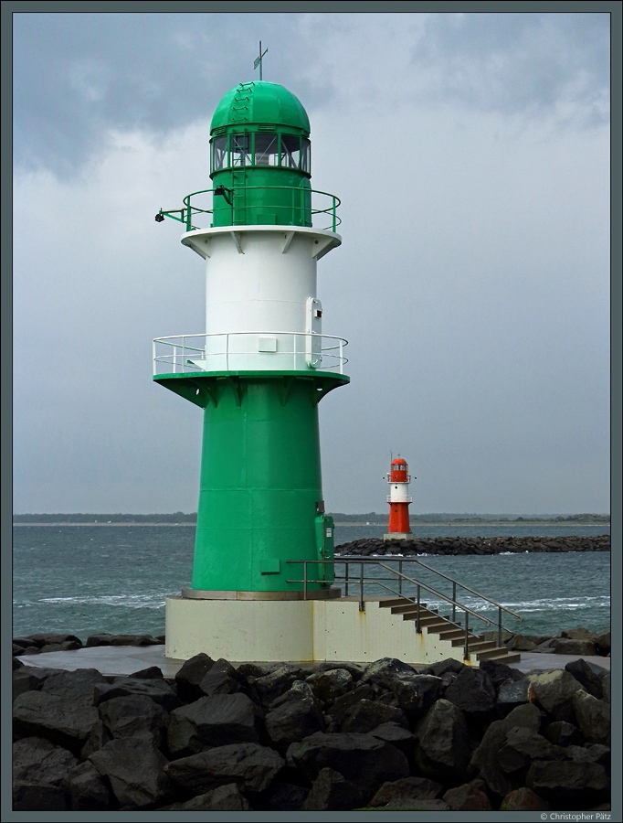 Die Hafeneinfahrt zur Warnow wird von zwei Molenfeuern flankiert. Im Vordergrund das Westmolenfeuer, im Hintergrund das rote-weiße Ostmolenfeuer. (Warnemünde, 20.08.2017)