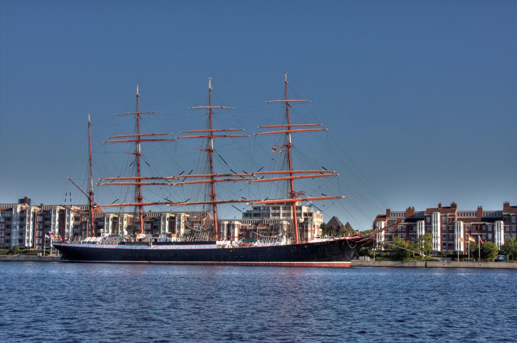 Die SEDOV, das derzeit größte Segelschiff der Welt, eine Viermast Bark, lag am 30.08.2016 noch am Bontekai in Wilhelmshaven. Das Schiff fährt unter russischer Flagge und ist eine Reparationsleistung nach dem zweiten Weltkrieg an die damalige Sowjetunion. Heute dienst es der russischen Marine als Segel Schulschiff. Der Besuch in Wilhelmshaven endete noch am Tag der Foto Aufnahme.