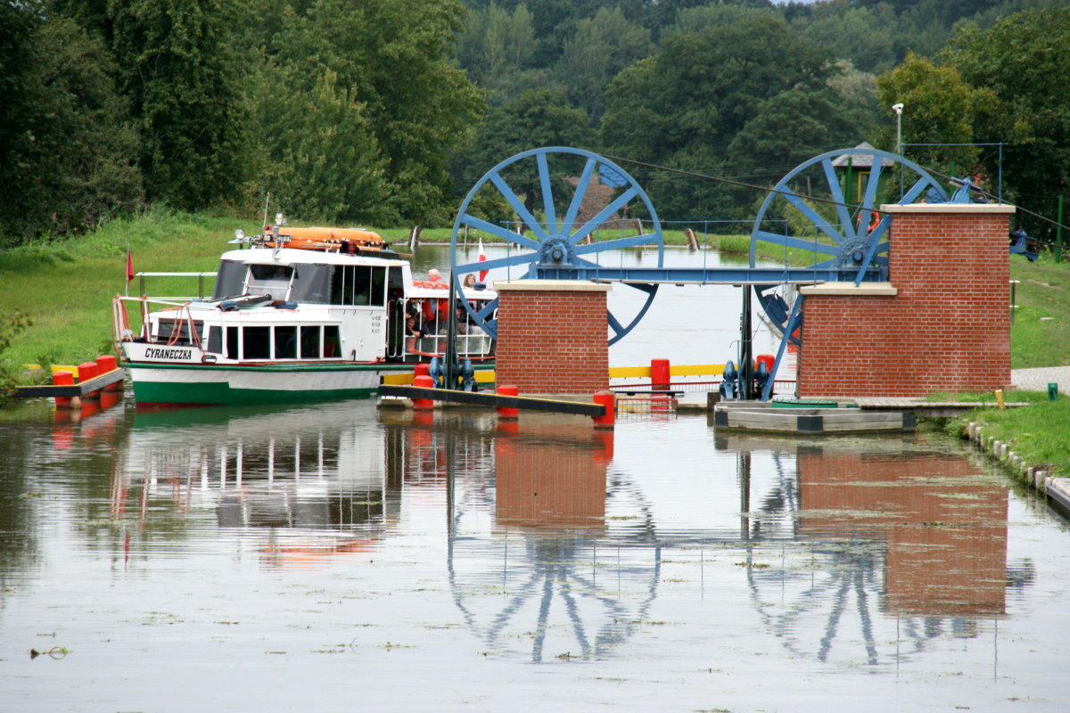 Die Seilscheiben oberhalb der Rollberge lenken die Zugseile von dem seitlich stehenden Maschinenhaus zum Rollberg um. Sie gehören zu den technischen Raffinessen am Oberländischen Kanal. Die M/S  Cyraneczka  umfährt die Seilscheiben vom Rollberg Katy; 10.09.2017