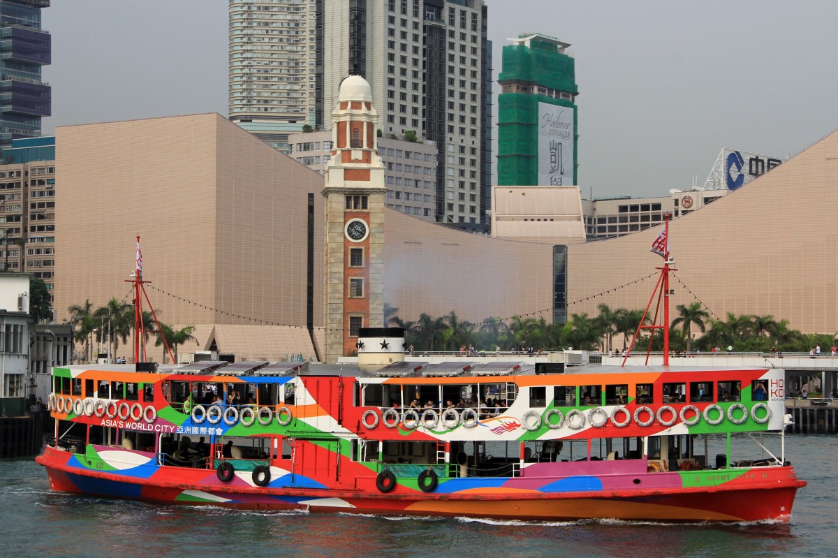 Die Star Ferry verbindet Hong Kong Island mit Kowloon, dem Festland. Zur Zeit stehen 10 Schiffe, alle gleichgebaut, im Einsatz. Die Schiffe wurden von 1956 bis 1965 gebaut und fassen 576 Personen. Die hier in Werbebemahlug für das Asia's World City fahrende Night Star wurde 1963 gebaut. Bild am 20.4.2014 am Star Ferry Pier aufgenommen.