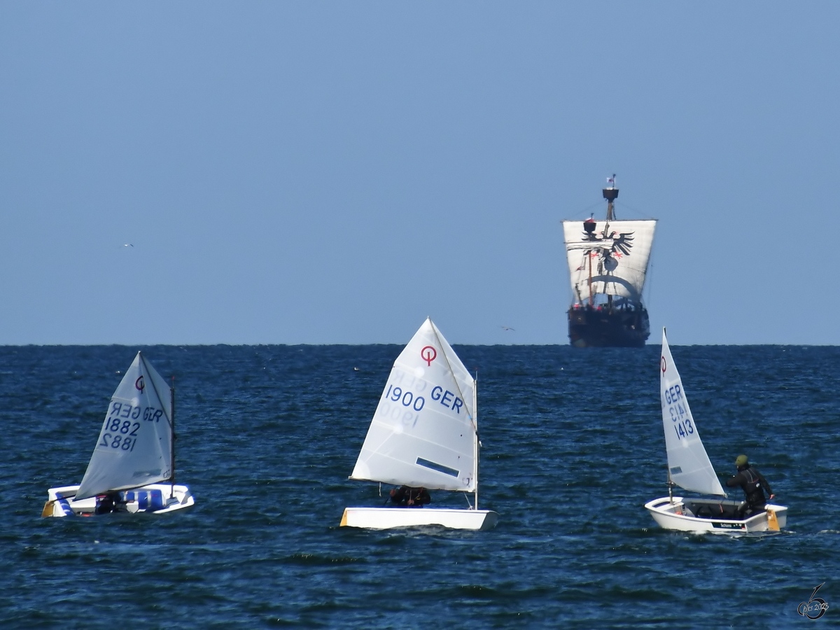 Drei Boote der Segelschule ziehen ihre Bahnen, im Hintergrund ist die LISA VON LÜBECK zu sehen. (Priwall, Mai 2023)