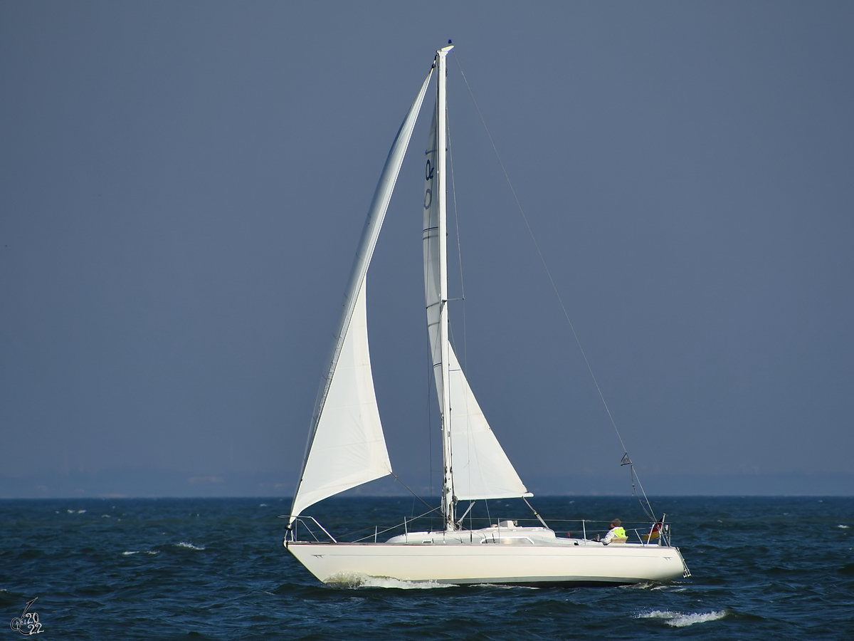 Ein einsames Segelboot zieht auf der Ostsee seine Bahnen. (Priwall, März 2022)
