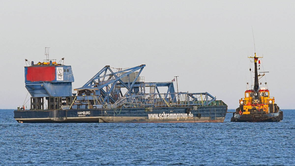 Ein Peiner-Kran aus dem Jahr 1975 von der LMG (Lübecker Maschinenbau Gesellschaft) in Lübeck wird auf Ponton P 3 von Lübeck nach Schacht-Audorf transportiert. Rechts im Bild: Schlepper LEVENSAU. Ostsee vor Lübeck-Travemünde, 29.10.2021