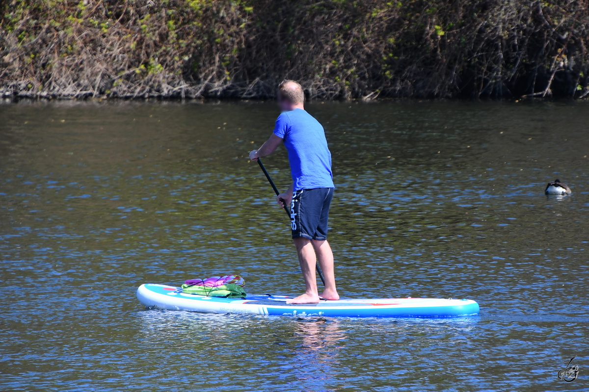 Ein Stehpaddler ist auf der Ruhr unterwegs. (Witten, April 2021)