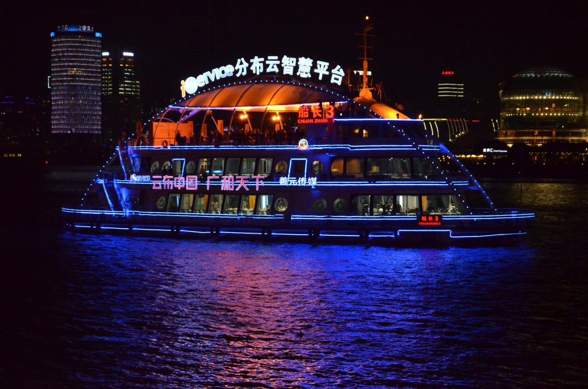 Ein Touristenschiff auf dem  Huangpu Jiang vor der Skyline von Pudong in Shanghai bei Nacht am 28.10.2014 beobachtet. 