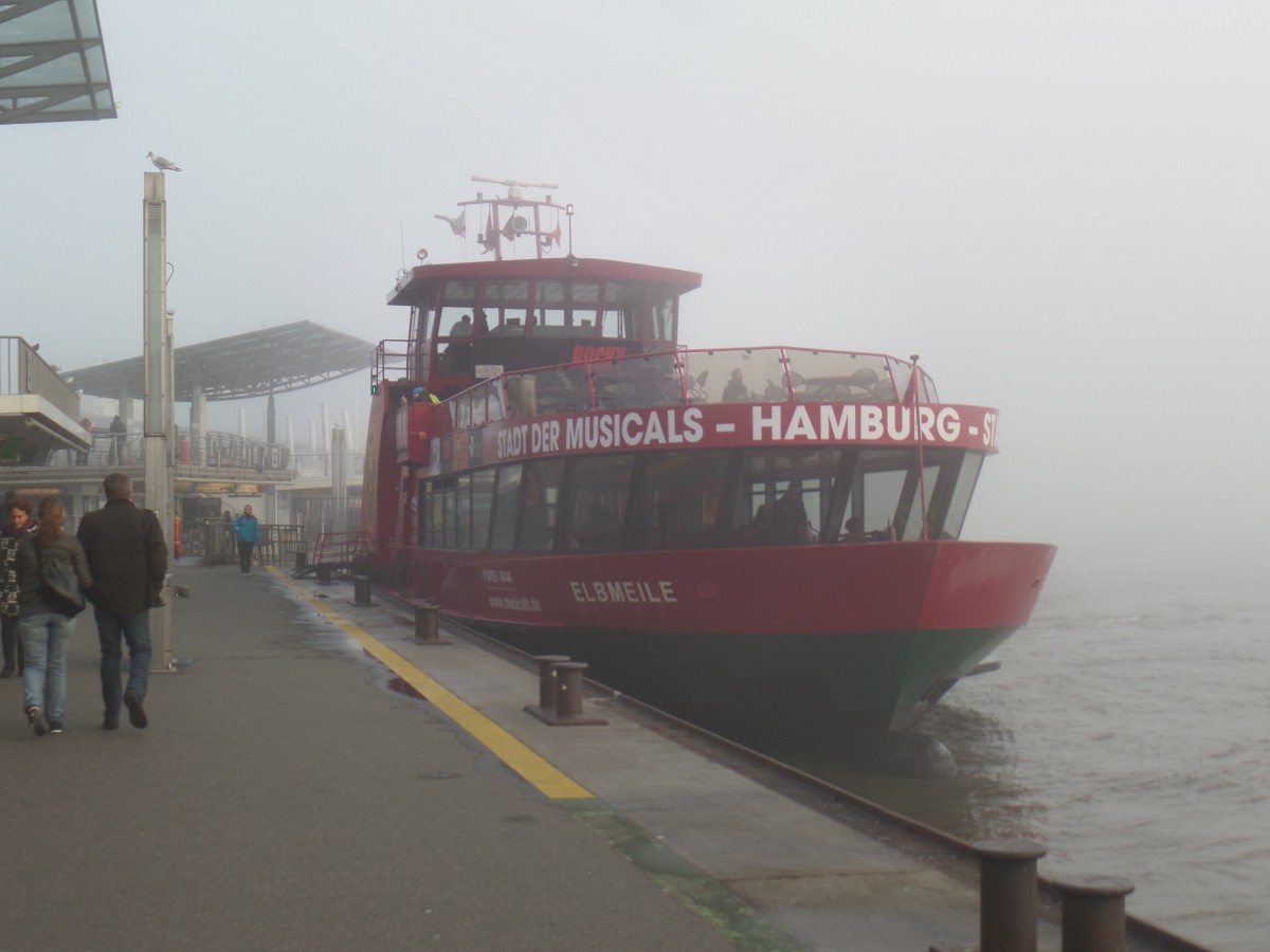 ELBMEILE (1) (ENI 04803440) am nebligen 25.11.2014, mit Werbung für  Stadt der Musicals , Hamburg, Elbe an den Landungsbrücken auf Linie 62 nach Finkenwerder /

Hafenfährschiff  HADAG-Typ 2000 / Lüa 29,94 m, B 8,15 m, Tg 1,7 m / 2 Diesel, Volvo-Penta D12-450,  ges. 662 kW, 2 Ruderpropeller, 12 kn, 1 Querstrahlruder / 250 Pass. / 2005 bei SSB, Oortkaten /
