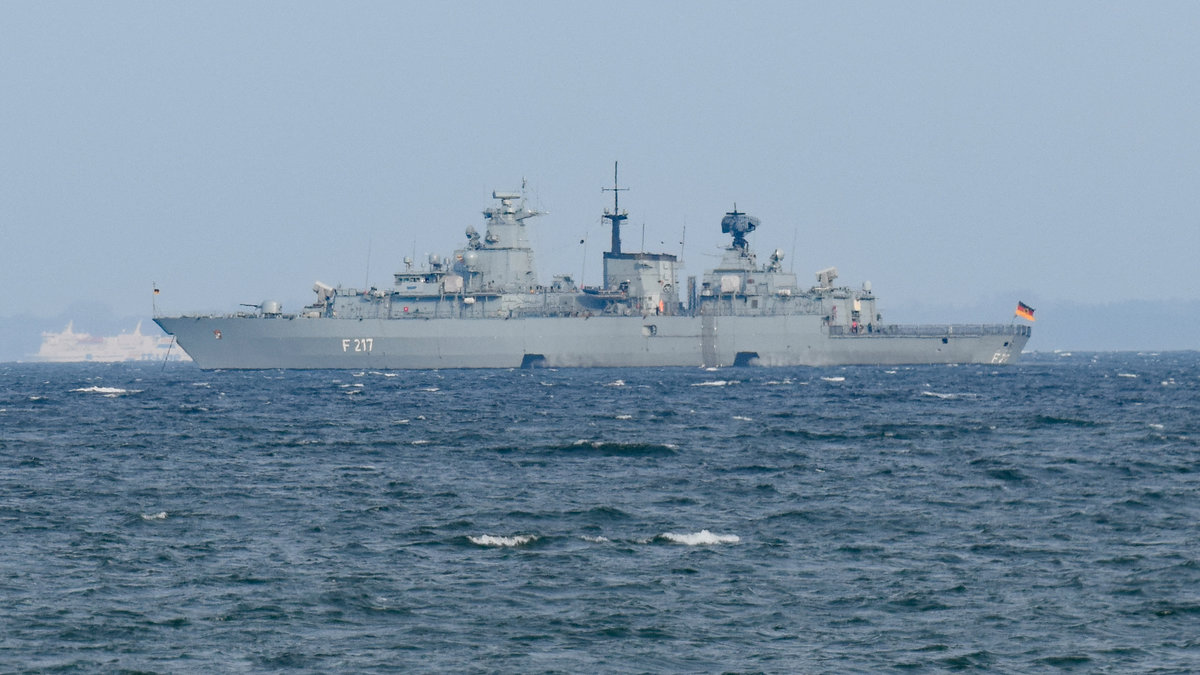 F 217 - Fregatte  BAYERN  der Deutschen Marine am 28.04.2021 in der Ostsee vor Scharbeutz. Im Hintergrund: ein Fährschiff der TT-Line