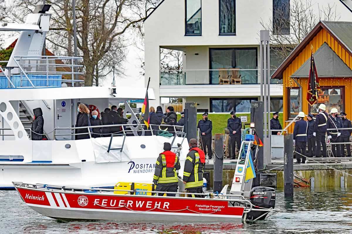 Feuerwehrboot HEINRICH am 14.01.2021 im Hafen von Niendorf / Ostsee. Es geleitet kurz darauf die auslaufende POSITANO (hauptsächlich für Seebestattungen eingesetzt) hinaus auf die Ostsee. Zuvor hatten Feuerwehrangehörige das Lied  Ich hatte einen Kameraden  gespielt. Als POSITANO schließlich ablegte, ertönte eine Sirene vom Dach eines Hafengebäudes und das Feuerwehrboot folgte mit eingeschalteten Blaulichtern. Bewegende und sehr emotionale Augenblicke! 