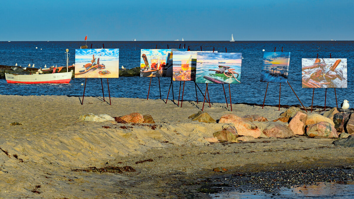 Fischereiboot SIE 101 WIM umgeben von am Strand der Ostsee bei Sierksdorf ausgestellten Bildern. Aufnahme vom 22.09.2021