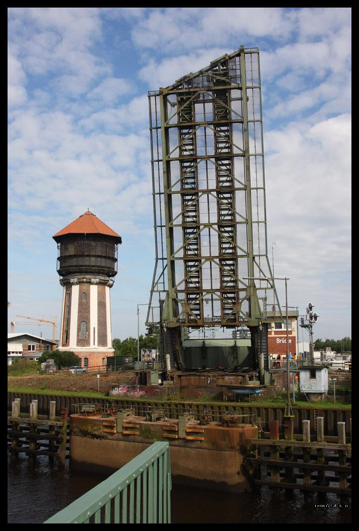 Gewaltig hoch wirkt die aufgeklappte Eisenbahn Brücke neben dem Oldenburger Wasserturm. Dabei ist es nur die halbe Brücke, die hier am 4.7.2016 hochgefahren wurde und über die Hunte emporragt.