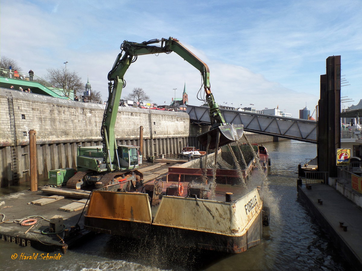 Hamburg am 16.3.2017, Baggerarbeiten zwischen Landungsbrücken und Ufer, Bagger beim Füllen der Klappschute FORELLE der Firma Arnold Ritscher /