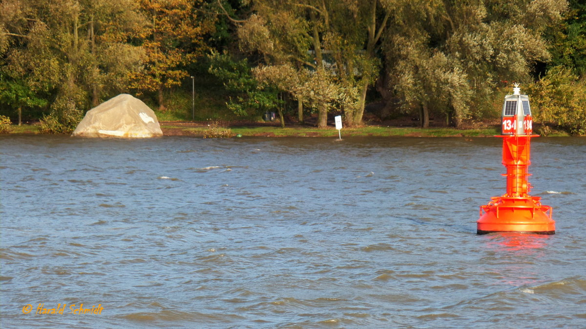 Hamburg am 29.10.2017: Fahrt mit einem HADAG-Fährschiff vorbei an der Fahrwassertonne 134 vor Övelgönne mit Blick auf das Ufer mit dem umspülten „Alten Schweden“ und dem hoch am Ufer stehenden Wasser bei der Sturmflut /  