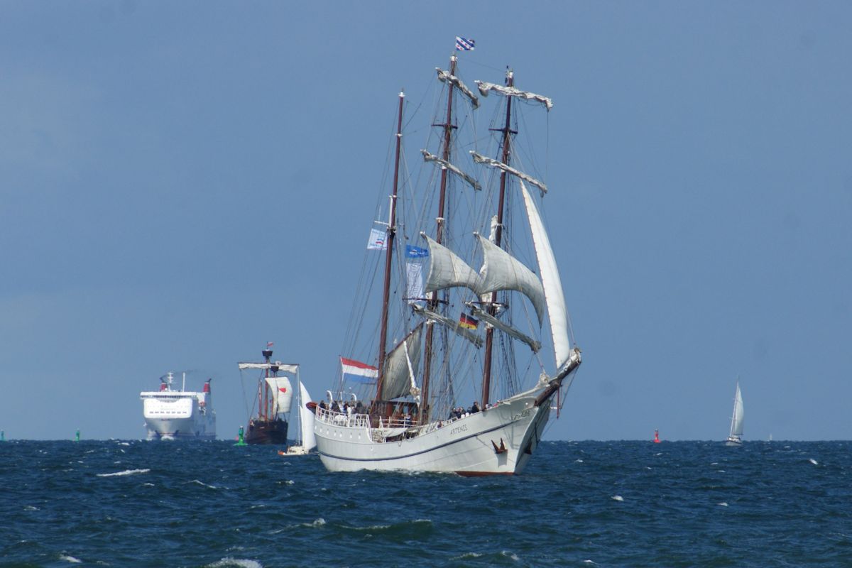 Im Rahmen der 26. Hanse Sail war die 3-Mast-Bark Artemis zu Rundfahrten unterwegs. Hier erreicht sie die Warnowmündung, während sich im Hintergrund die Fähre Mecklenburg Vorpommern nähert. (11.08.2016)