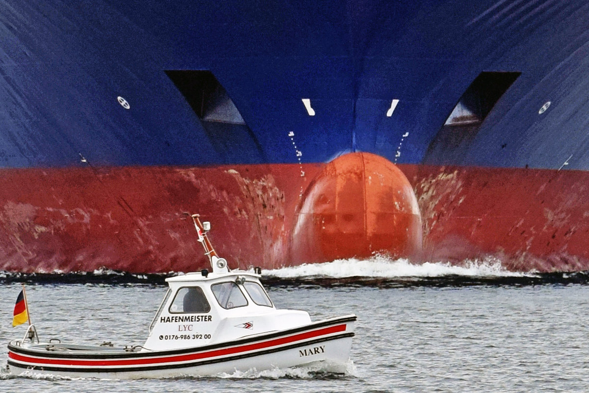 Jetzt aber schnell aus dem Weg... MARY, Hafenmeister LYC, am 2.4.2021 auf der Trave bei Lübeck-Travemünde vor dem näher kommenden Containerschiff SPIRIT