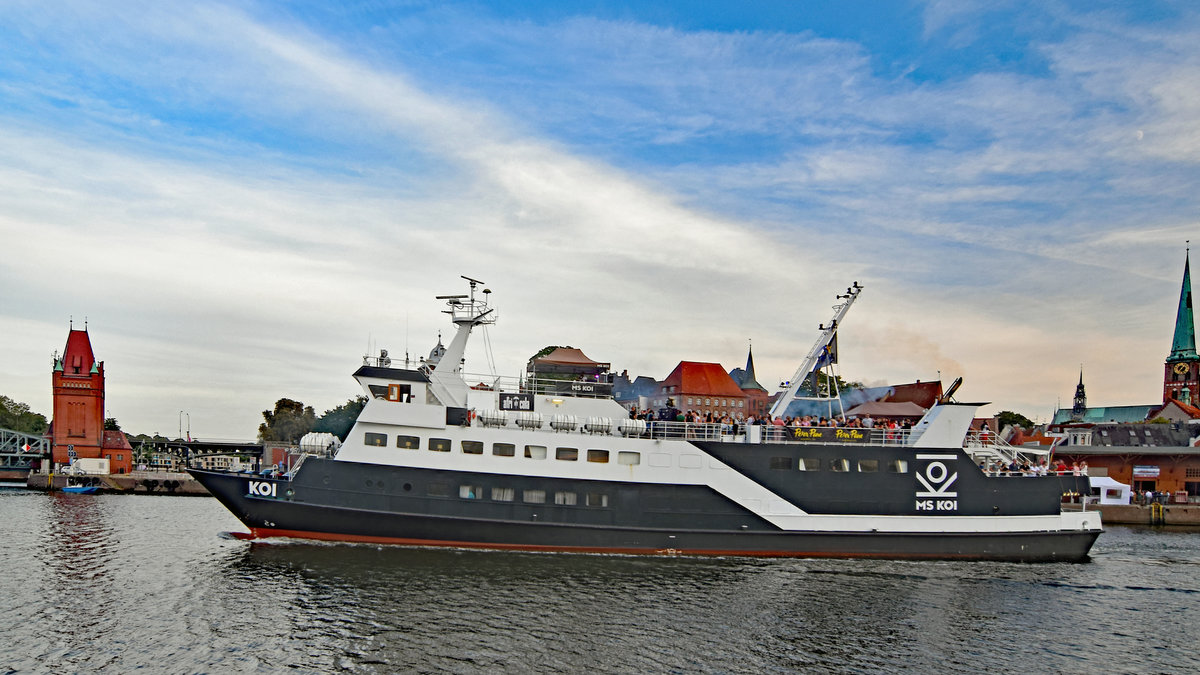 KOI (IMO 7928615)am 18.8.2018 gegen 19.15 Uhr in Höhe Burgtor bzw. Hubbrücke Lübeck. KOI, Baujahr 1980, wurde im Frühjahr 2014 zum Veranstaltungsschiff umgebaut und fährt nun als Event- und Partyschiff auf Nord- und Ostsee. Das Schiff wurde in der Husumer Schiffswerft gebaut. Zeitweise war es als Fähre in Dänemark unterwegs und wurde bei zahlreichen Törns auch zum beliebten zollfreien Einkauf genutzt. Seit dem Jahr 2005 gehört das Fahrzeug zur Reederei Adler-Schiffe und fuhr dort bis zu seinem Umbau unter dem Namen „Adler-Dania“ als Ausflugsschiff. Länge 53,60 Meter, Breite 10,10 Meter, Platz für 550 Fahrgäste.