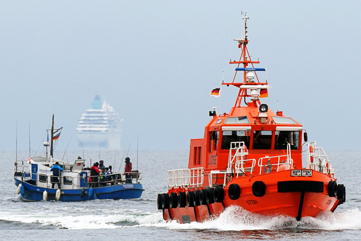 Lotsenversetzboot STEIN am 04.12.2021 in der Ostsee vor Lübeck-Travemünde. Im Hintergrund: PROFESSOR OEFTERING (mit Angel-Gästen) und das Kreuzfahrtschiff AMADEA