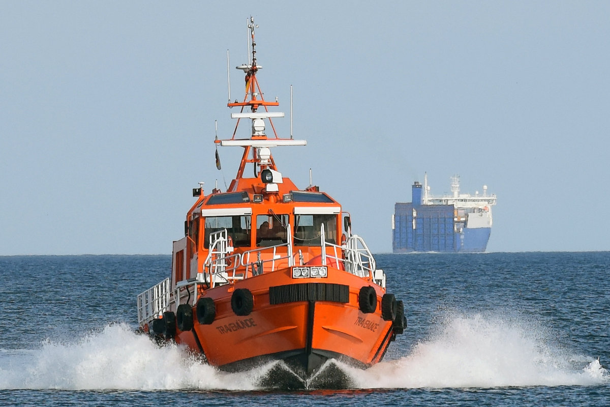 Lotsenversetzboot TRAVEMÜNDE vor Lübeck-Travemünde am 18.02.2018. Im Hintergrund der Autotransporter HAFNIA SEAWAYS